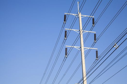 Power pole on stand. Electrical wires on a pole on blue sky background. Electric supply of big city. Land communications.