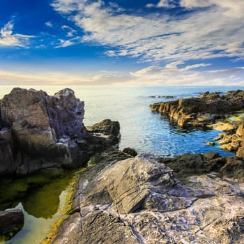 calm sea wave touch giant boulders on rocky shore