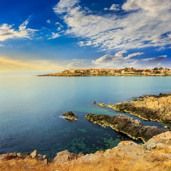 ancient european city on a rocky shore near sea in summer at sunrise