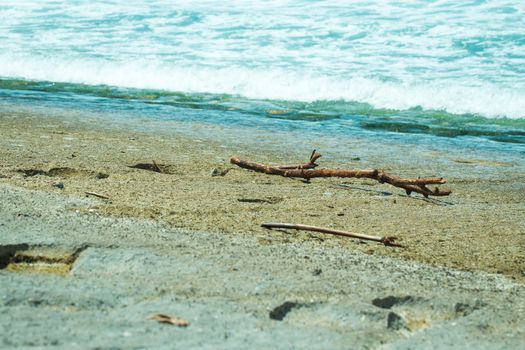 Sea water, waves, sand and stones, sea foam, sticks, stuck on the beach