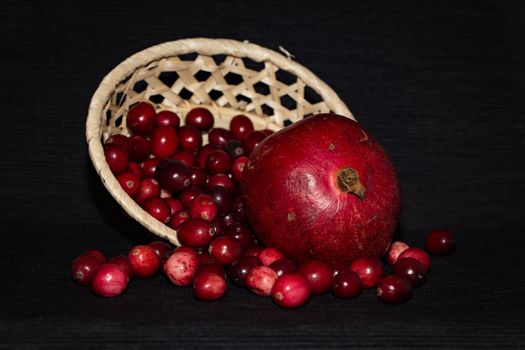 Pomegranate and lingonberry in a wooden basket