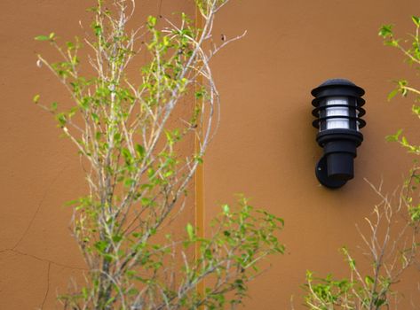 wall lamp on orange outdoor wall, black outdoor lamp