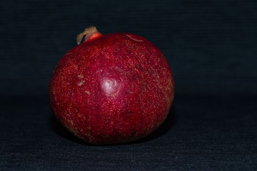 Red pomegranate on a black background close up