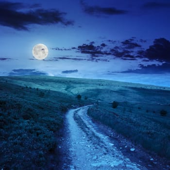 gravel road going on hillside to highlands at night in moon light