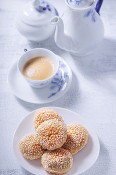 Almonds cookies with coffee on a white surface