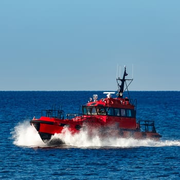 Red pilot ship moving from the Baltic sea