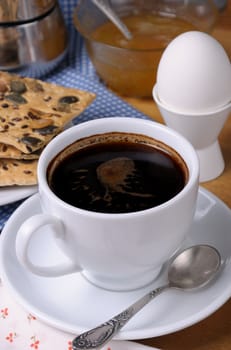 cup of coffee with a soft-boiled egg and toast for breakfast