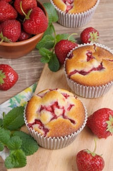 muffin with strawberries on a table among the berries and mint