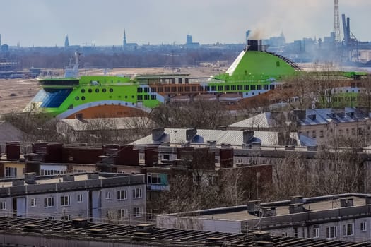 Green cruise liner. Passenger ferry sailing past the Riga city