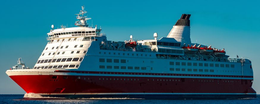 Red cruise liner. Large passenger ferry underway