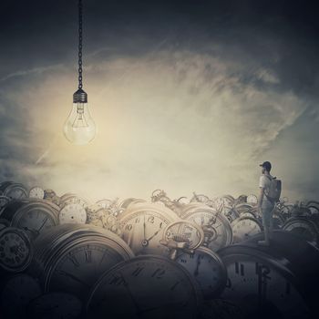 Surreal view as a man, with a bag in his back, stand in the midle of a clock trash looking at a huge light bulb glowing. Time pressure, hour perception and idea concept.