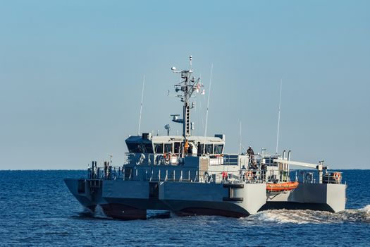 Small grey military ship moving from Baltic sea