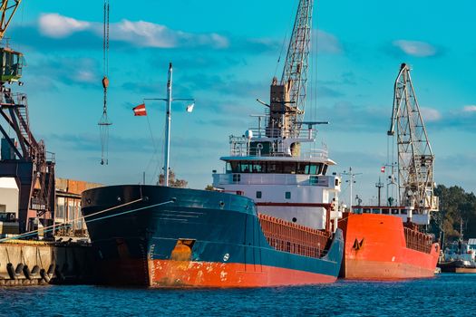 Blue cargo ship moored and loading at the port