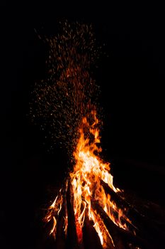 Campfire with flying sparks isolated on black background