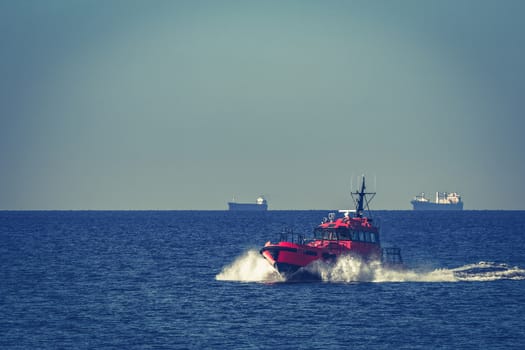 Red pilot ship moving from the Baltic sea
