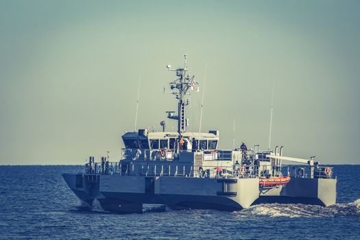 Small grey military ship moving from Baltic sea