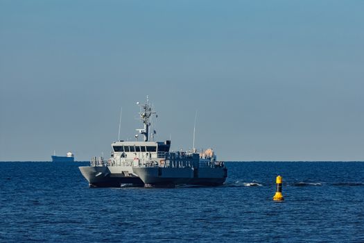 Small grey military ship moving from Baltic sea
