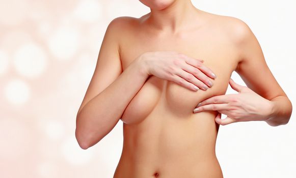 Woman pressing her breast to check the breast cancer