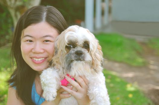 Young beautiful asian girl with the shizhu dog in the park.