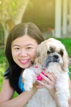 Young beautiful asian girl with the shizhu dog in the park.