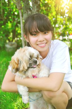 Young beautiful asian girl with the shizhu dog in the park.