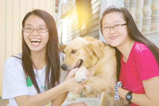 Pretty asian girls playing with a dog outdoor