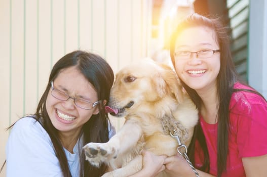 Pretty asian girls playing with a dog outdoor