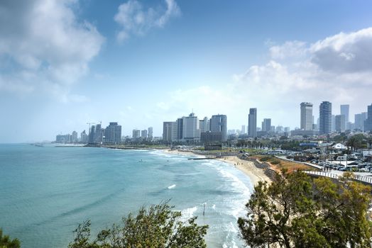 Tel Aviv skyline by day with beach, sea and waves