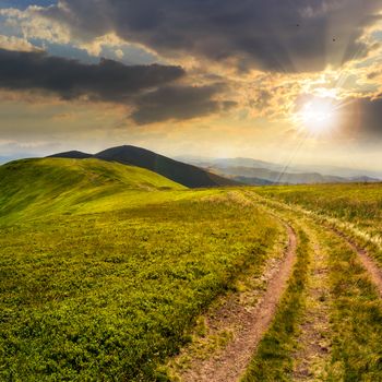 mountain landscape. path in valley  on the top of hillside at sunset