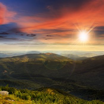 mountain landscape. valley with stones on the hillside. forest on the mountain under the beam of light falls on a clearing at the top of the hill at sunset