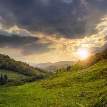 autumn landscape. village on the hillside. forest on the mountain light fall on clearing on mountains at sunset