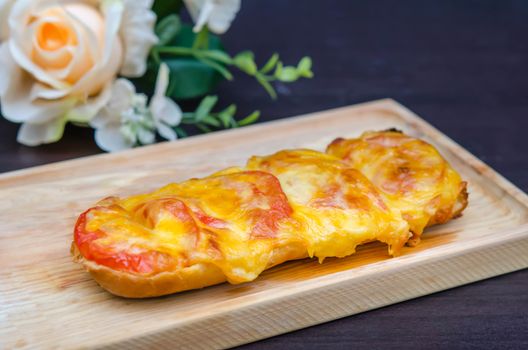 homemade French bread roll, topped with fresh tomatoes, melted cheddar, Mozzarella and Parmesan