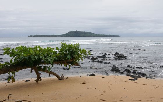 Praia Inhame with view over to Ilheu das Rolas on an overcast and rainy day, Sao Tome and Principe, Africa