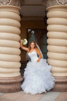 Stylish bride in a white dress in the countryside