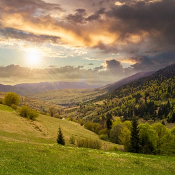 autumn landscape. village on the hillside. forest on the mountain light fall on clearing on mountains at sunset