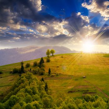 autumn landscape. village on the hillside. forest on the mountain light fall on clearing on mountains at sunset