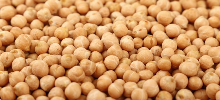 Dried chickpea beans at retail market display, close up pattern background, high angle view
