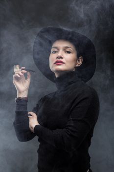 girl in black holding a pipe on smoke background
