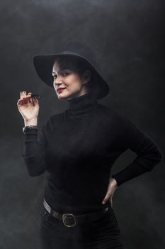 girl in black holding a pipe on smoke background