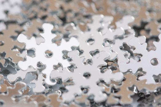 Christmas decoration of silver confetti snow flake against white background with nice boke. Close up confetti with shallow DOF