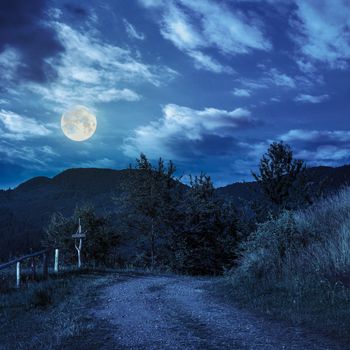 summer landscape. fence near the path on the hillside in high mountain at night in full moon light