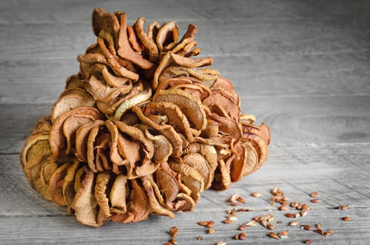 Dried apples strung on a thread, grey wooden background