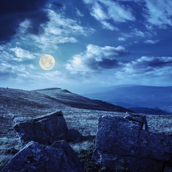 white sharp stones on the hillside at night in full moon light