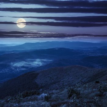 white sharp stones on the hillside or great mountain range at night in full moon light. collage
