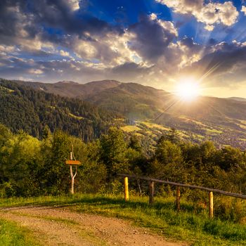 summer landscape. fence near the path on the hillside in high mountain at sunset