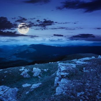 white sharp stones on the hillside in hight mountains at night in moon light