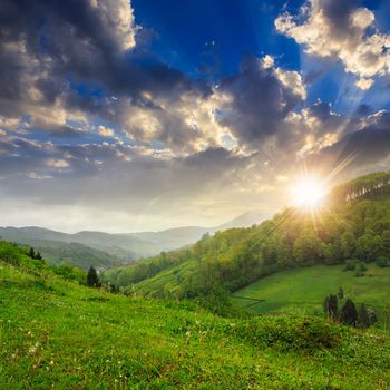 cold morning fog on meadow and forest in the mountains at sunset