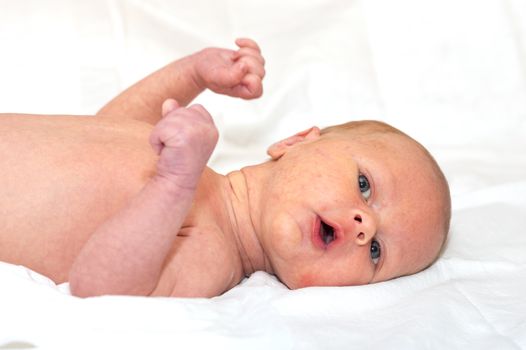 Close up shot of boy newborn jaundice lying on white bed sheet