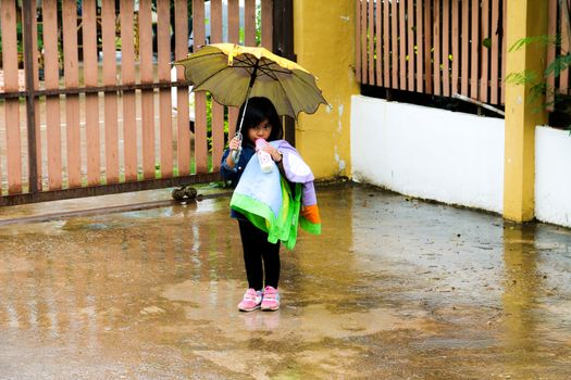 Little girl Drinking  milk with umbrella in the rain