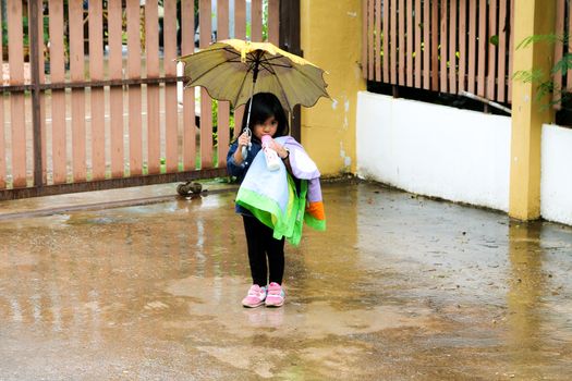 Little girl Drinking  milk with umbrella in the rain